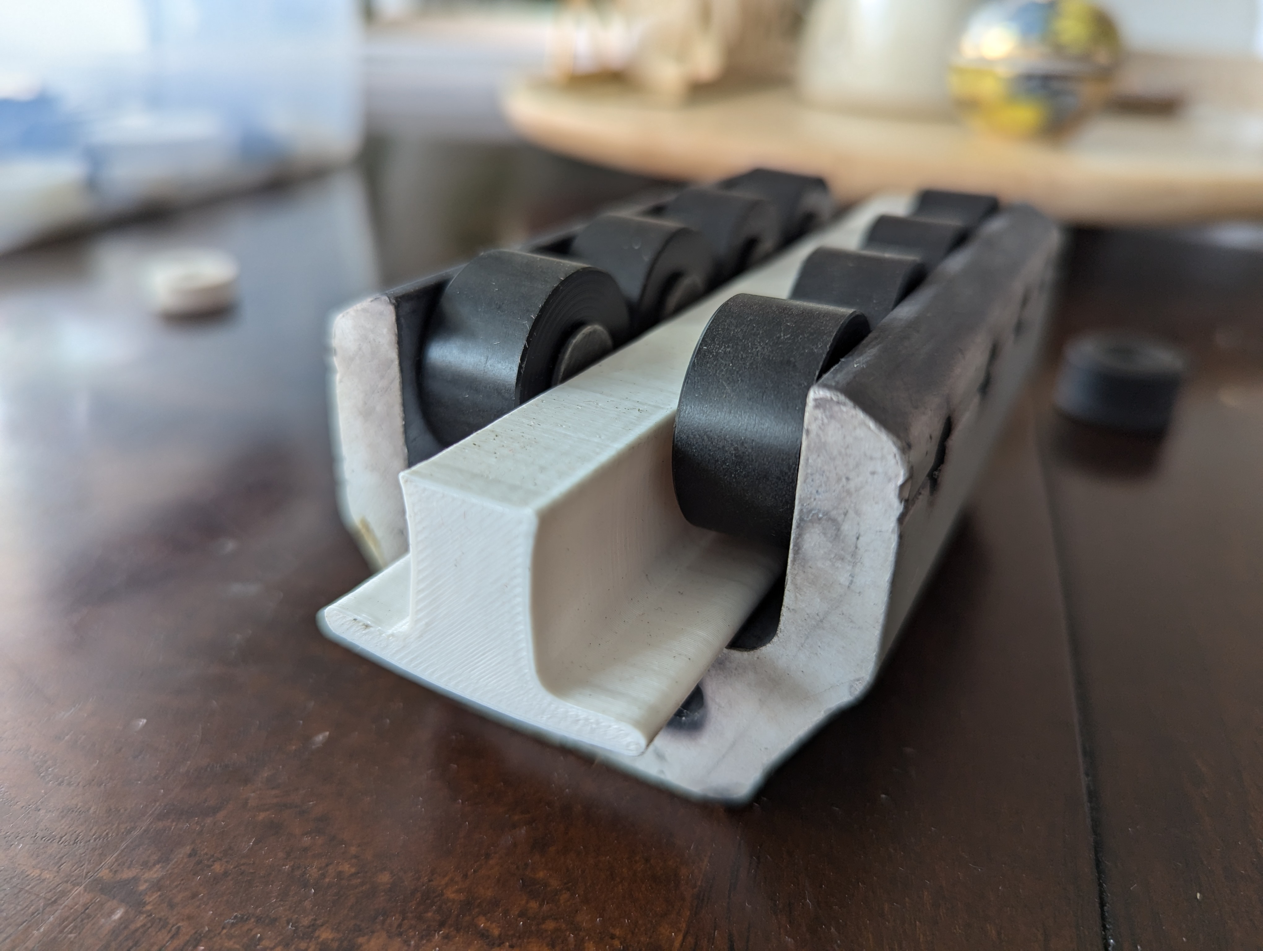 Traveler car with eight new wheels installed with pins in original orientation, shown on a plastic track segment.